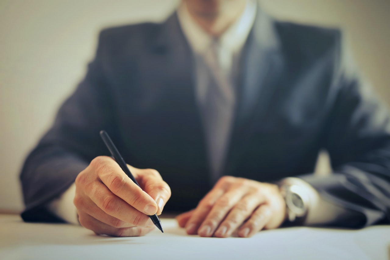 man signing a type of employment contract